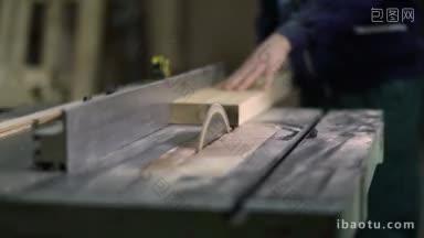 木匠在电圆锯上切割木板，工人的<strong>手</strong>在车间用台式锯切割木材特写